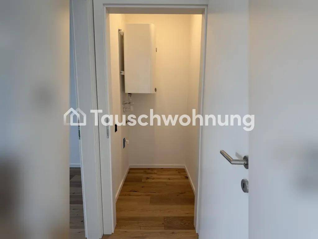 Kleiner Hauswirtschaftsraum mit Warmwasserbereiter und Holzboden, ideal als Abstellkammer.