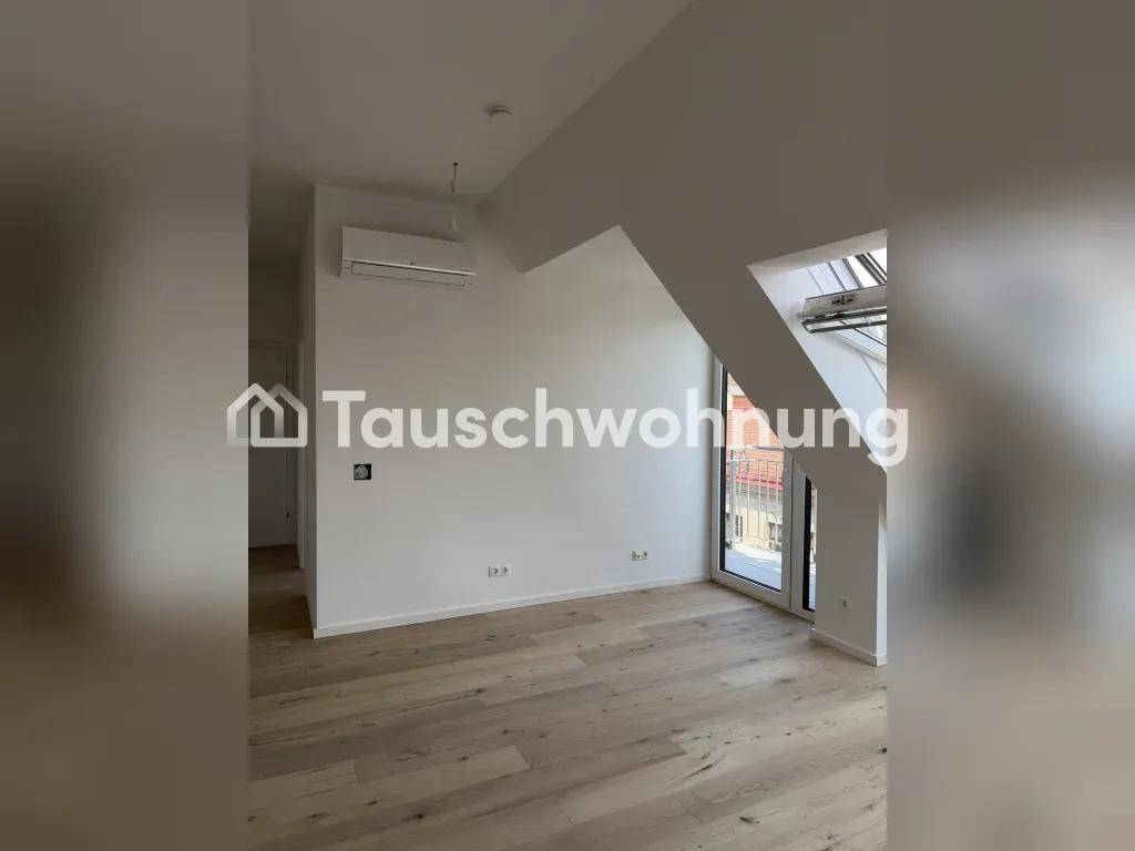 Heller Raum im Dachgeschoss mit schrägen Wänden, großen Dachfenstern und Klimaanlage.