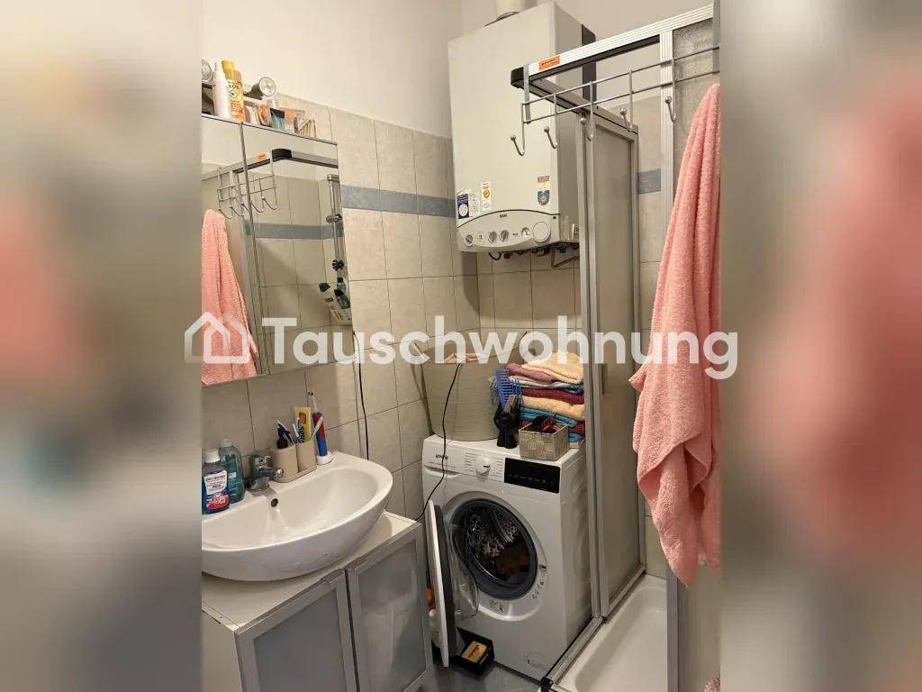 Kleines Badezimmer mit Waschbecken, Spiegelschrank, Waschmaschine und Duschkabine.