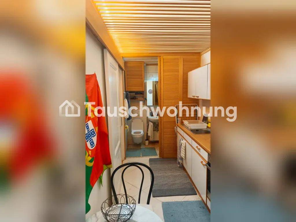 Küchenzeile mit Spüle und Blick auf das angrenzende Badezimmer mit WC.