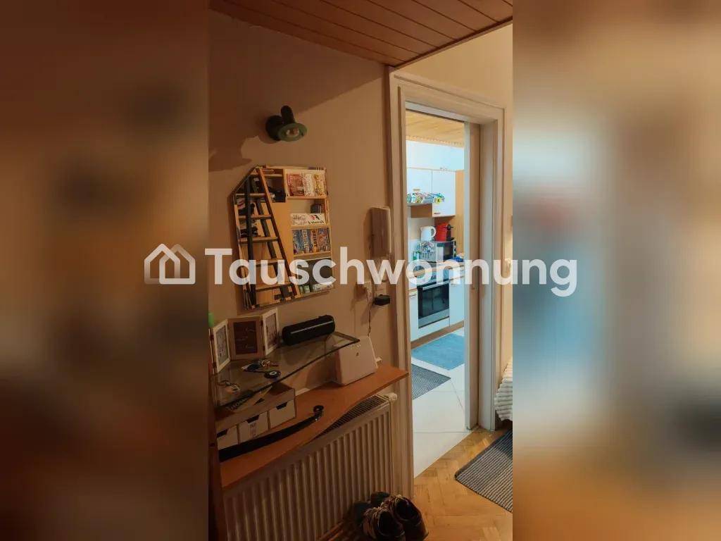 Flur mit Heizkörper und Blick durch die Tür in eine helle Küche.