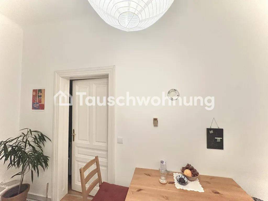 Essbereich mit Holztisch und Stühlen, beleuchtet von einer modernen Deckenlampe.
