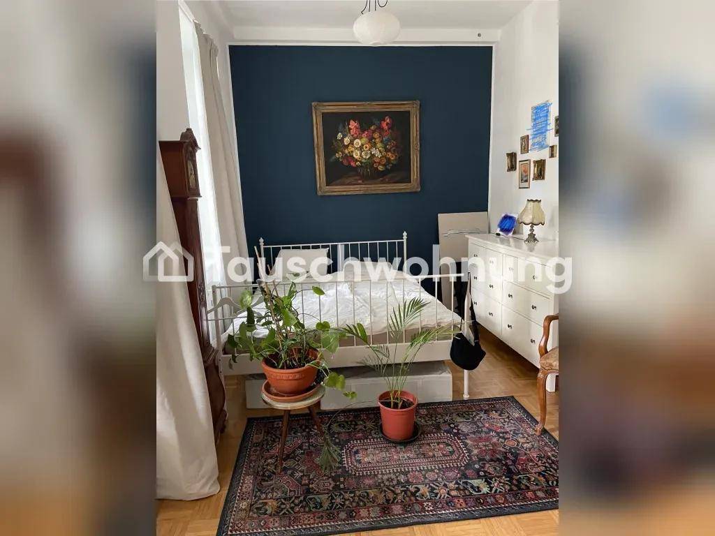 Gemütliches Schlafzimmer mit dunkler Akzentwand, Doppelbett und traditionellem Teppich auf Parkettboden.
