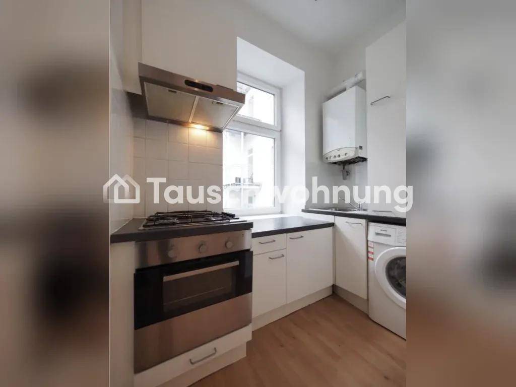 Kompakte Küche mit Gasherd, Backofen, Waschmaschine und weißen Einbauschränken.