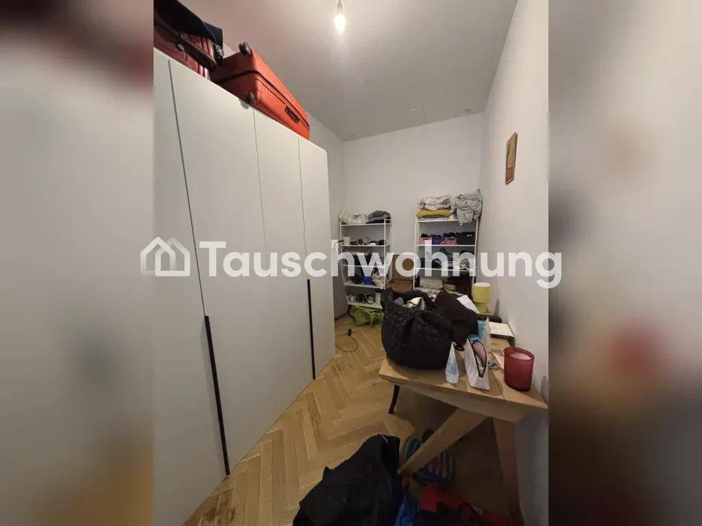 Schlafzimmer mit großen weißen Kleiderschränken und Parkettboden, bietet viel Stauraum.