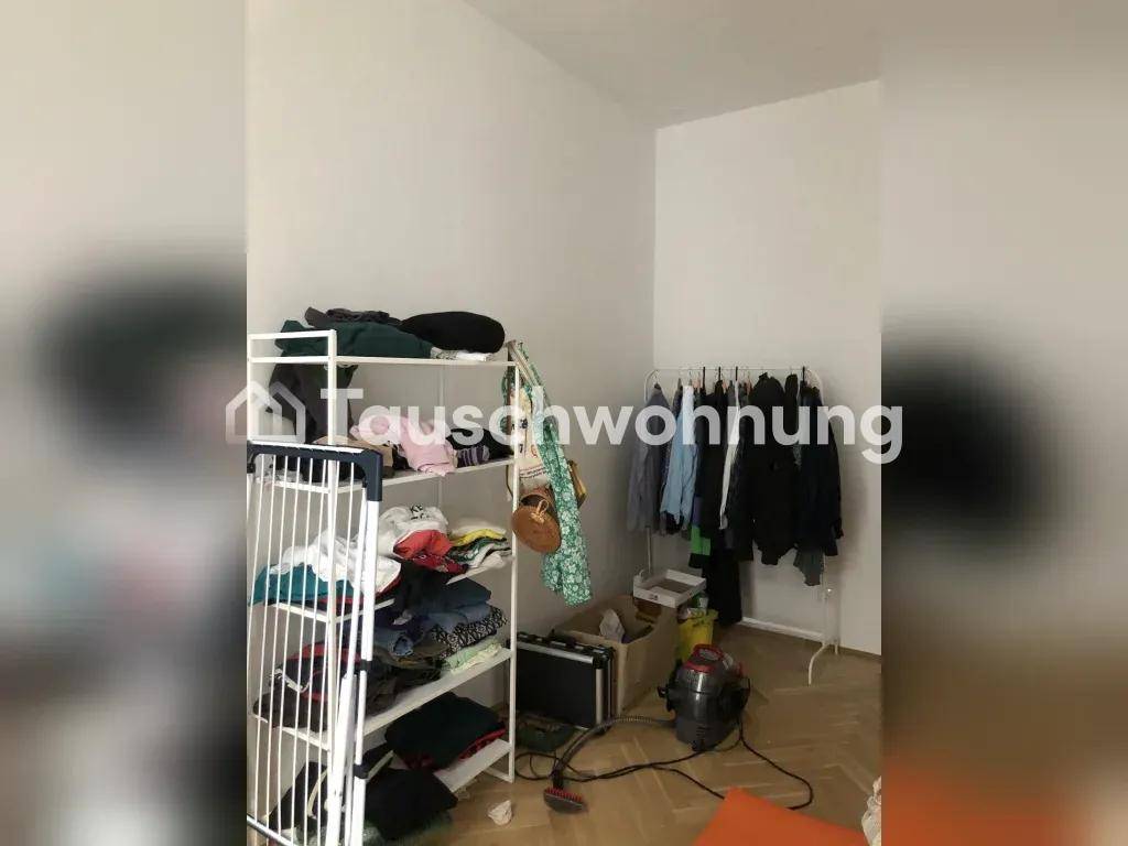 Schlafzimmer oder Ankleidezimmer mit Kleiderständern und Regalen, ausgestattet mit Parkettboden.