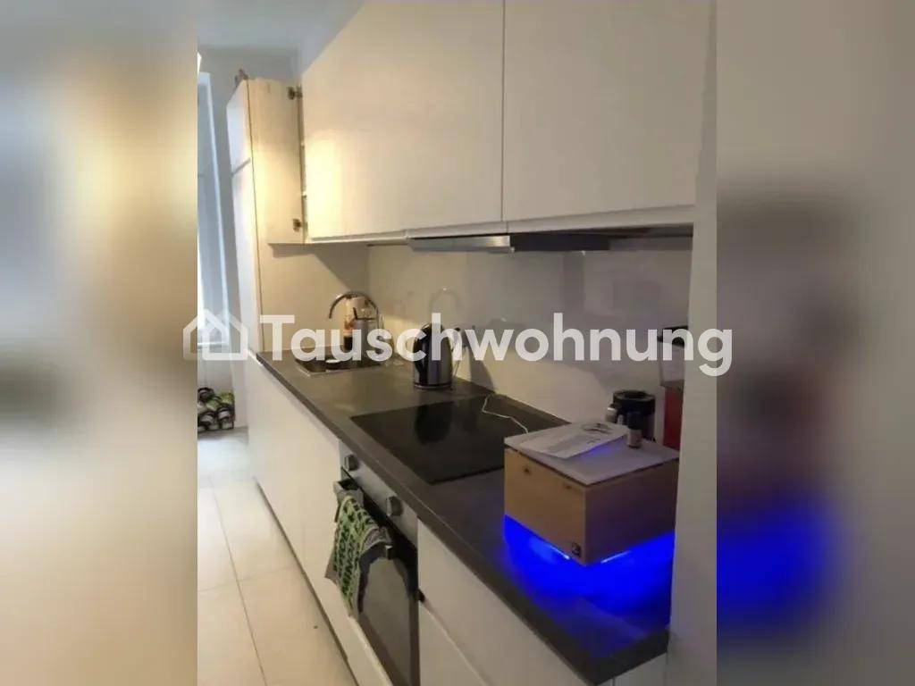 Moderne Küchenzeile mit weißen Schränken, dunkler Arbeitsplatte und integriertem Kochfeld.