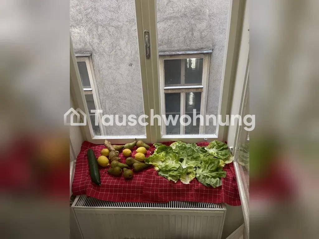 Fensterbank mit frischem Obst und Salat auf einem karierten Tuch über einem Heizkörper.