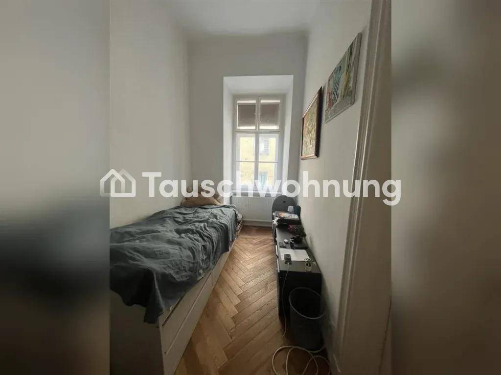Schmales Schlafzimmer mit Einzelbett, Parkettboden und Fenster, bietet eine gemütliche Atmosphäre.