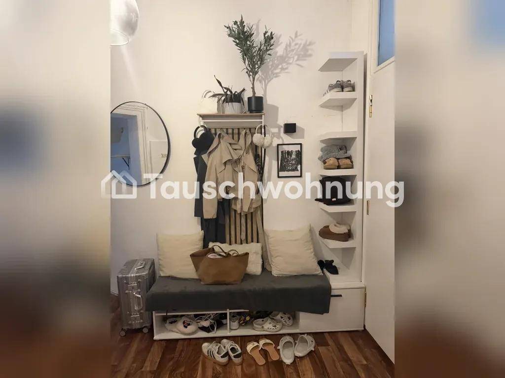 Heller Eingangsbereich mit Garderobe, Schuhregal und Sitzbank mit Kissen.
