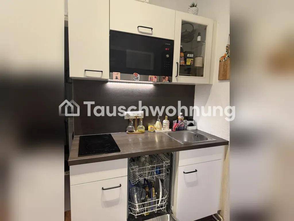 Kompakte Küchenzeile mit integriertem Geschirrspüler, Kochfeld und Mikrowelle.
