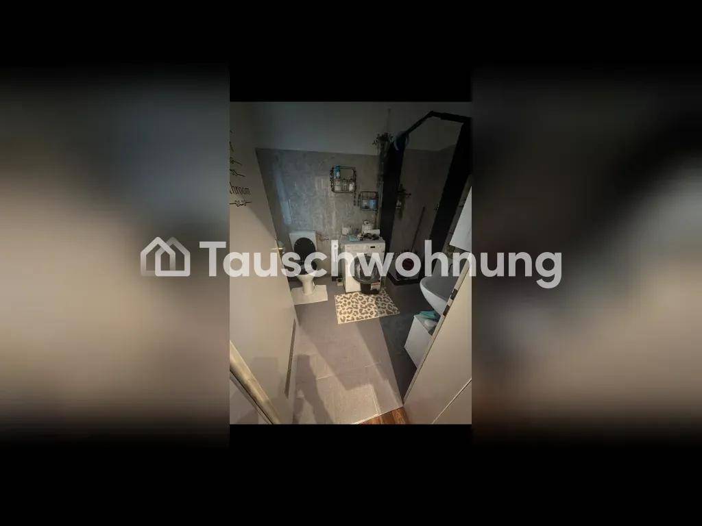 Modernes Badezimmer mit grauen Fliesen, Toilette und Waschbecken, von oben fotografiert.