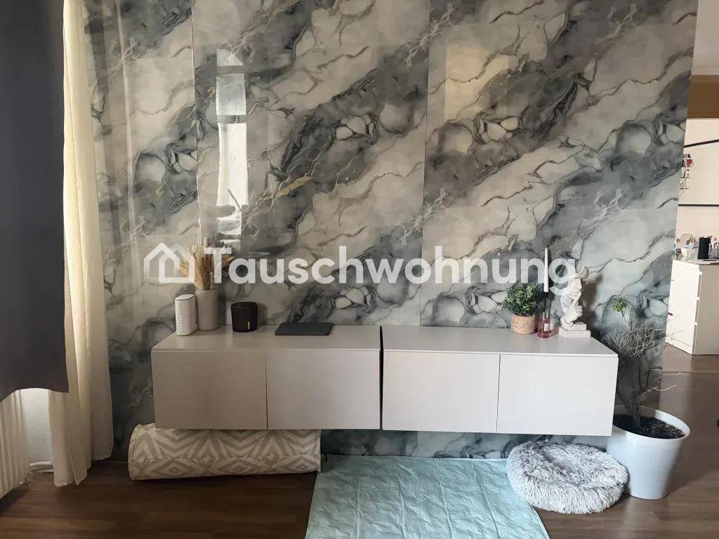 Wohnzimmer mit moderner Wandverkleidung in Marmoroptik und schwebendem TV-Möbel.