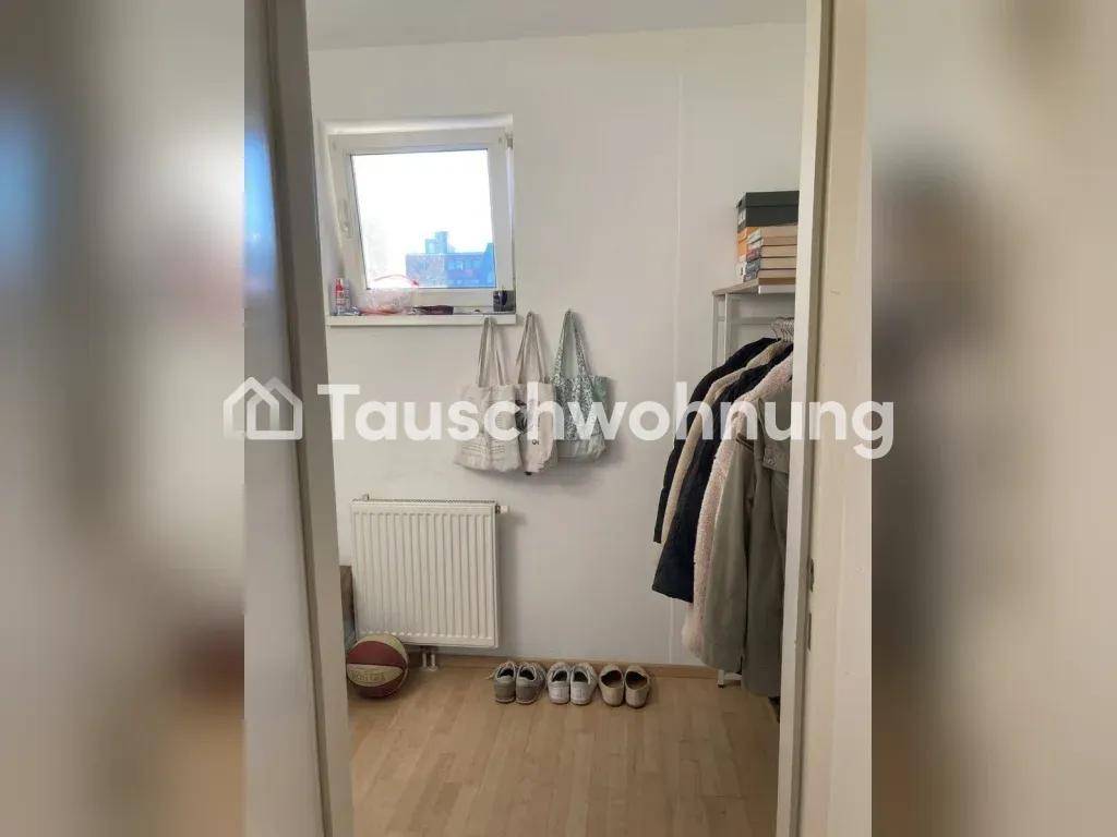 Kleiner Flur mit Fenster, Heizkörper und Stauraum für Kleidung und Schuhe.