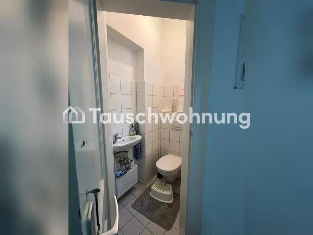 Kleines Gäste-WC mit Toilette, Waschbecken und Fliesen an Wänden und Boden für einfache Pflege.