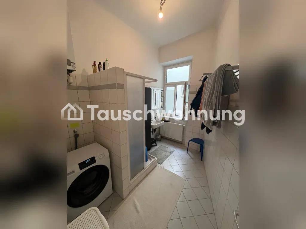 Helles Badezimmer mit Duschkabine, Waschmaschine und Fenster für gute Belüftung und Tageslicht.