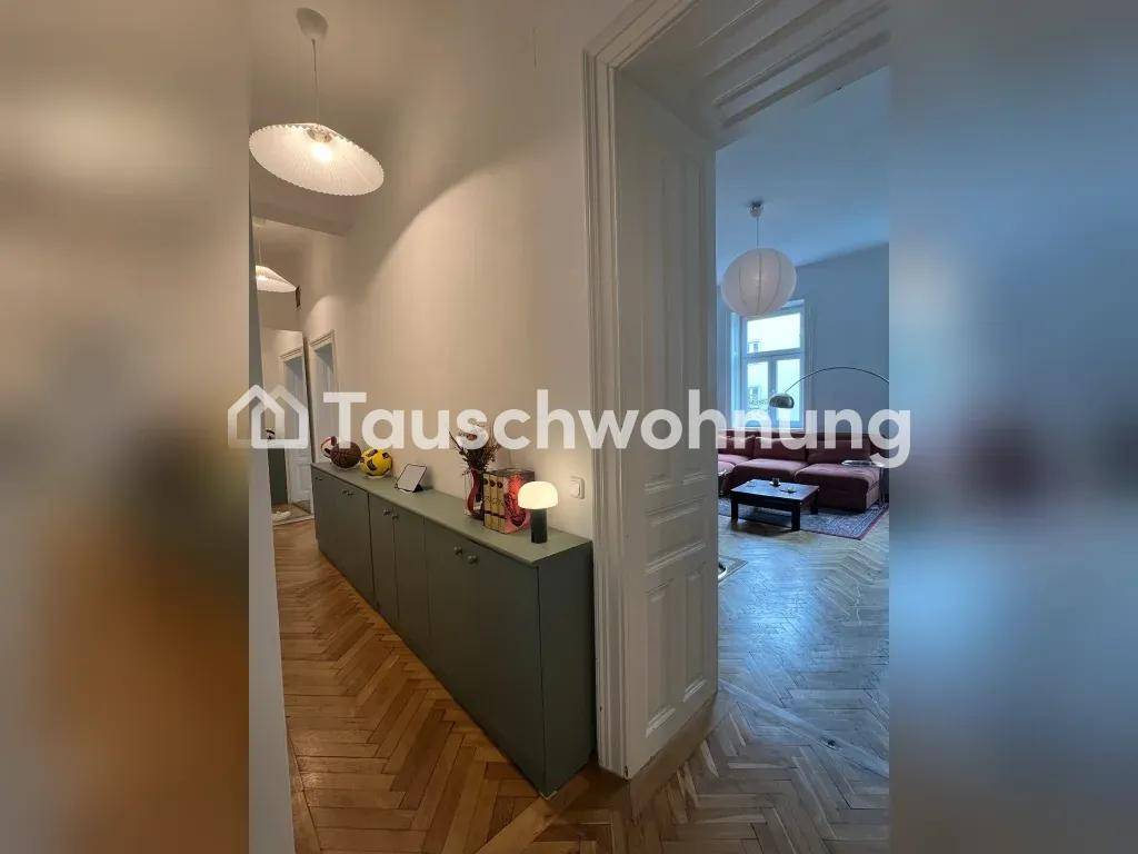 Langer Flur mit Fischgrätparkett und einem einladenden Blick in das angrenzende Wohnzimmer.