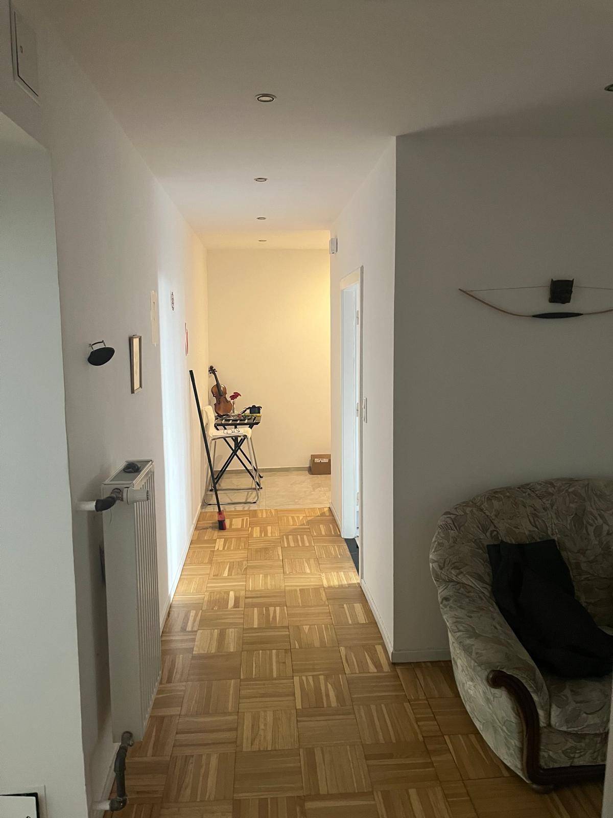 Heller Flur mit Parkettboden, der zu weiteren Räumen der Wohnung führt.