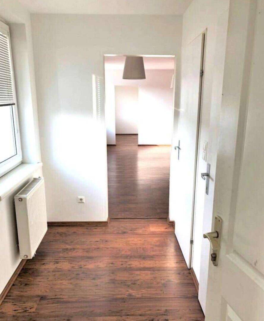 Heller Flur mit Laminatboden und Zugang zu weiteren Räumen der Wohnung.