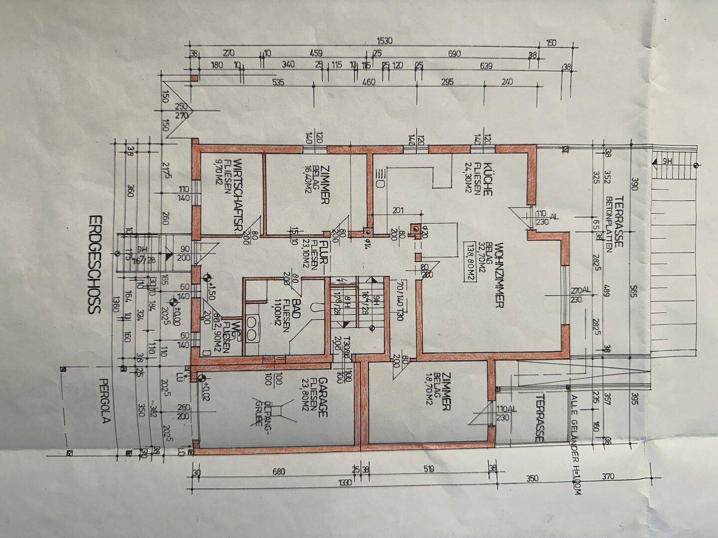 Grundriss des Erdgeschosses mit Wohnzimmer, Küche, Zimmern und Terrasse.