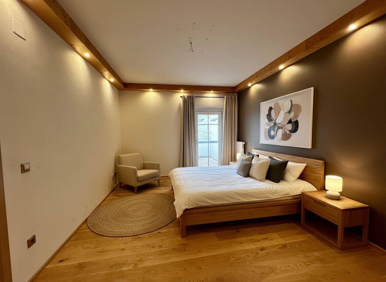 Gemütliches Schlafzimmer mit Holzbett, Parkettboden und indirekter Beleuchtung.
