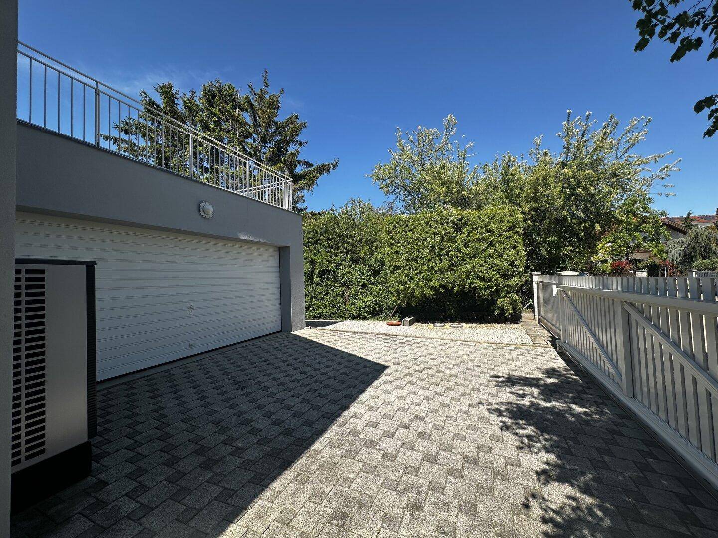 Gepflasterte Einfahrt vor der Garage mit Zugang zur oberen Terrasse.