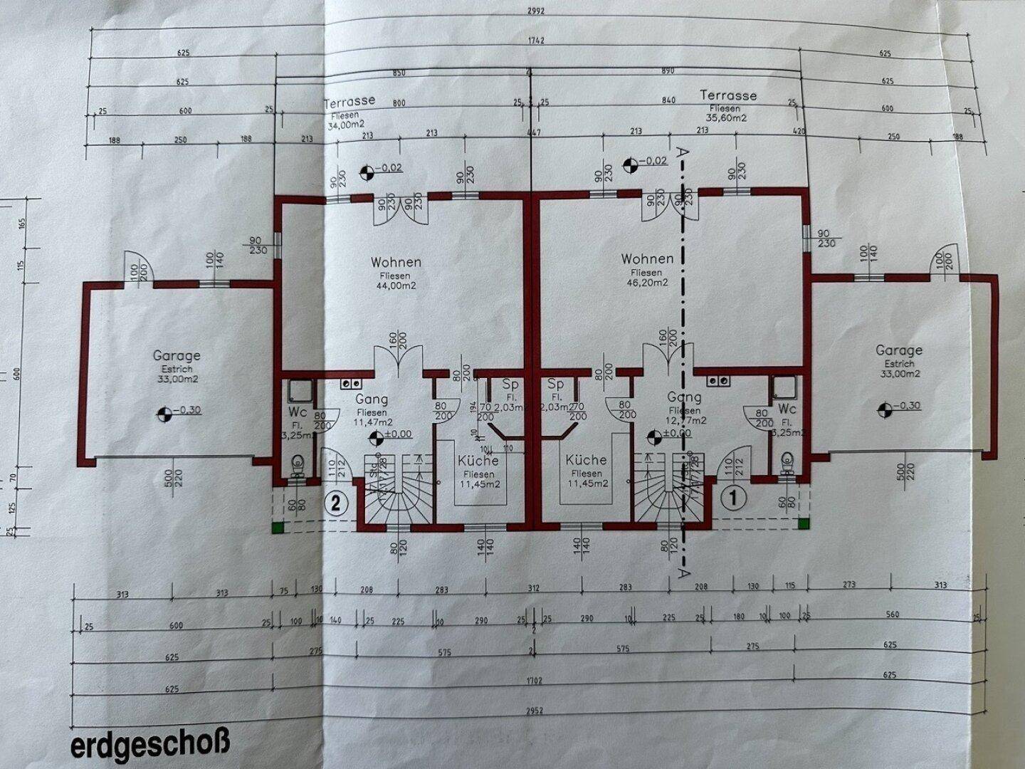 Grundriss des Erdgeschosses mit Wohnbereich, Küche, WC, Terrasse und Garage.