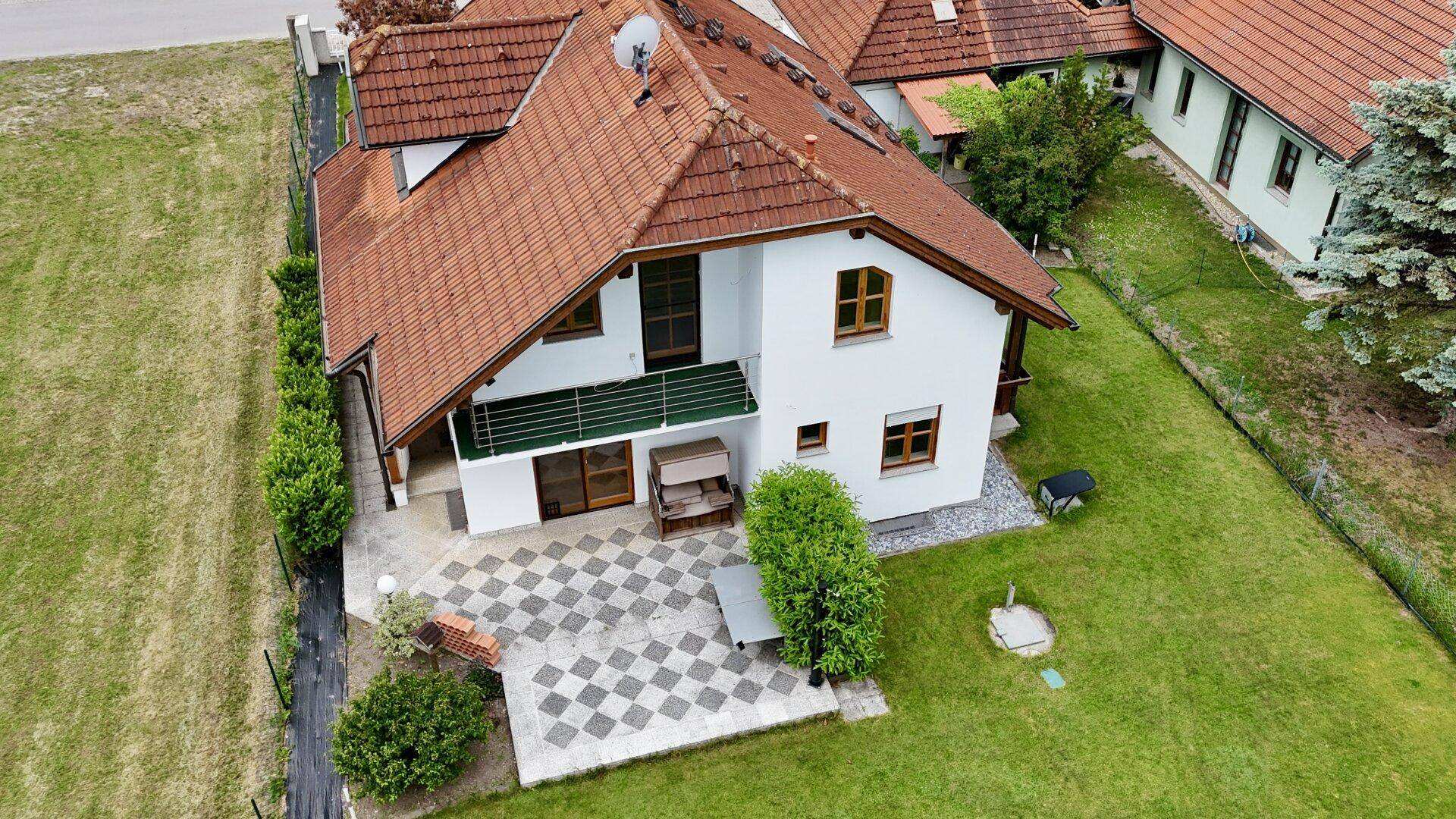 Luftaufnahme des Hauses mit Terrasse, Balkon und großem Gartenbereich.
