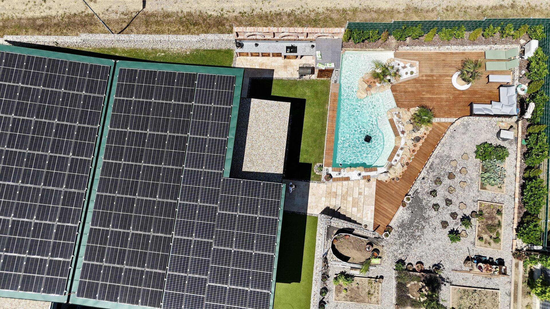 Luftaufnahme des Anwesens mit Photovoltaikanlage, Pool und angelegtem Gartenbereich.