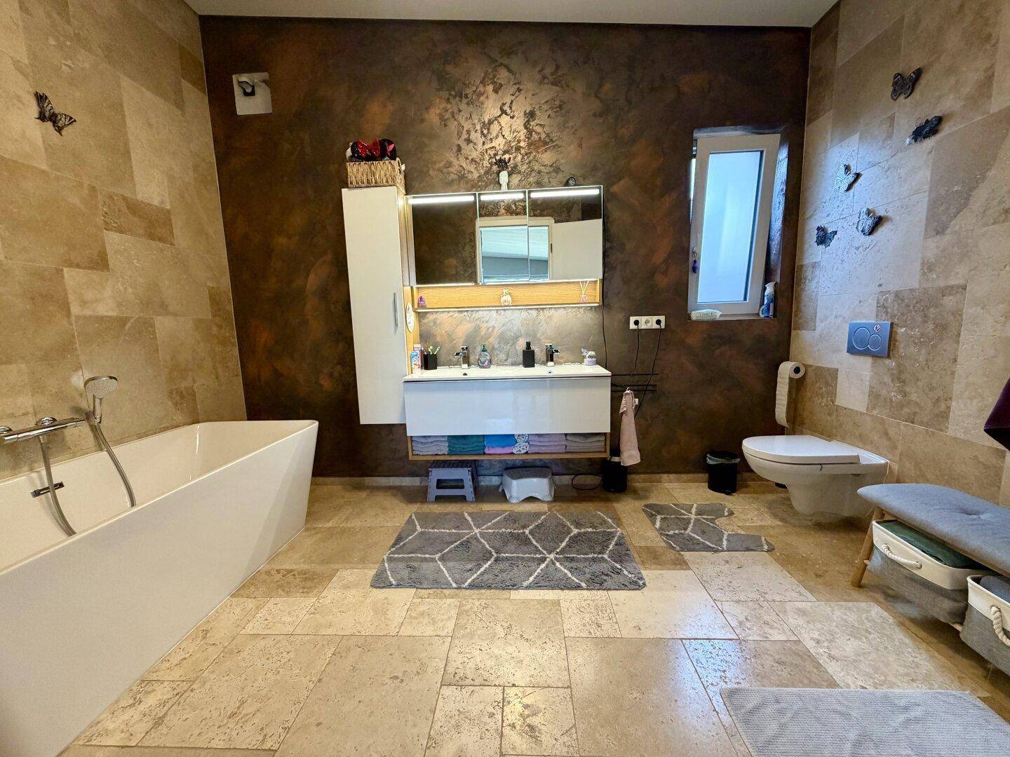 Modernes Badezimmer mit freistehender Badewanne, Doppelwaschbecken und Fliesenboden.