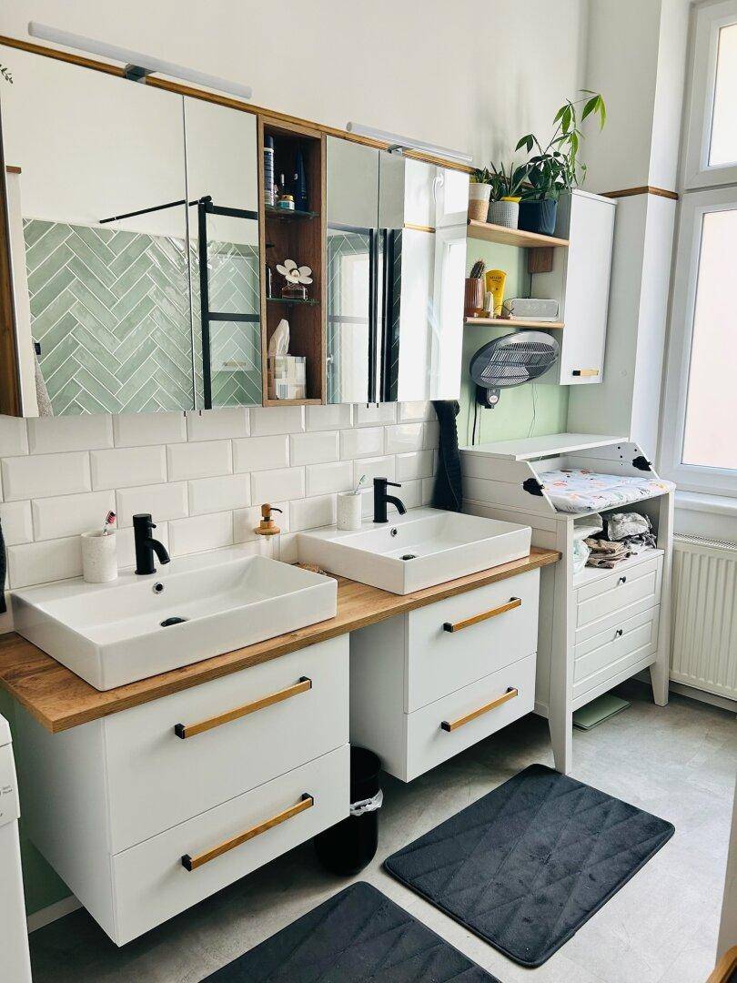 Helles Badezimmer mit Doppelwaschbecken, Spiegelschränken und Wickeltisch, ideal für Familien.