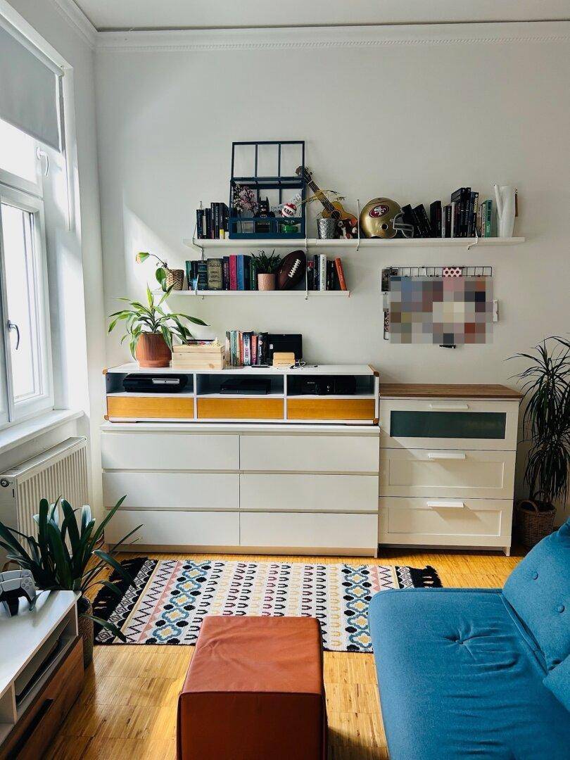 Funktionaler Arbeitsbereich mit Kommoden, Regalen und einem Fenster, das viel Tageslicht hereinlässt.