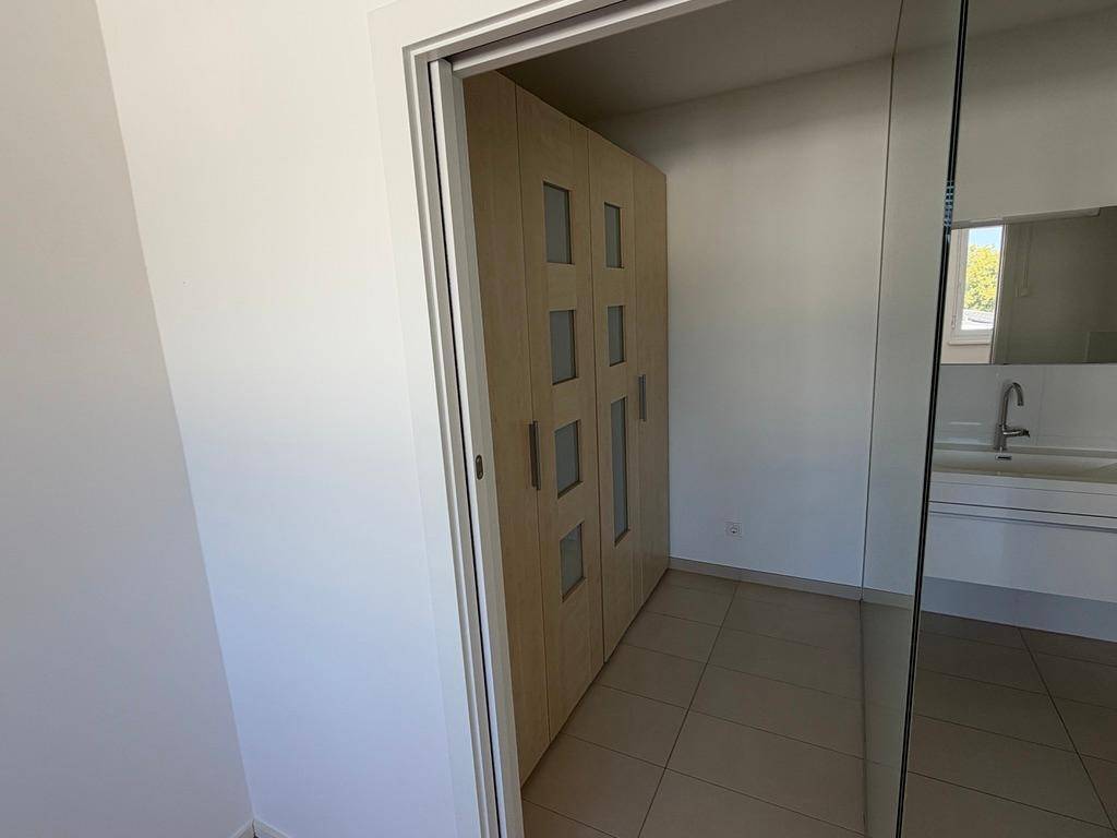 Badezimmer mit integrierten Holzschränken, modernem Waschbecken und Spiegelfläche.