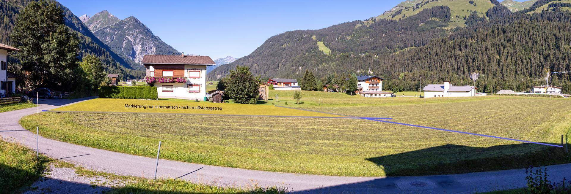 Weitläufige Ansicht einer ländlichen Landschaft mit grünen Feldern, Bergen und einer schematisch markierten Grundstücksgrenze.