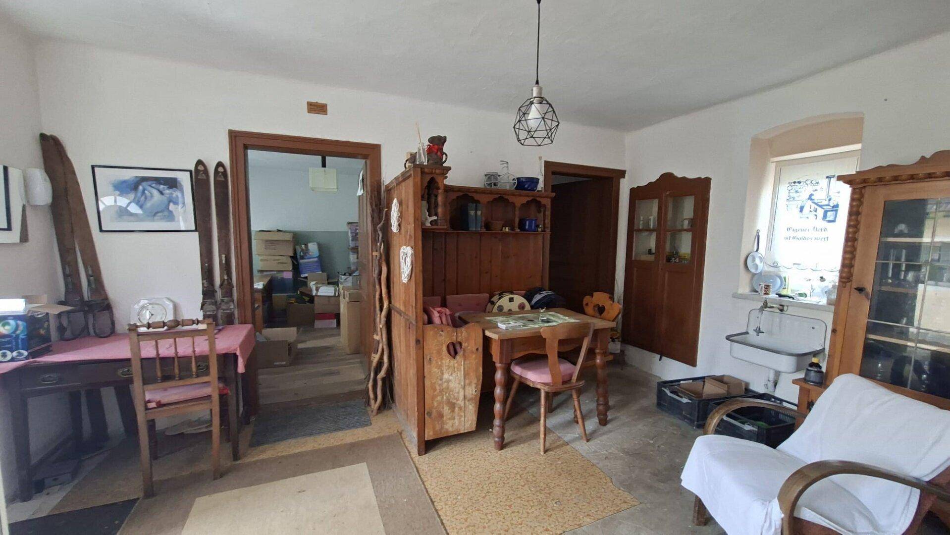 Geräumiger Wohnbereich mit traditionellen Holzmöbeln und einem Waschbecken.