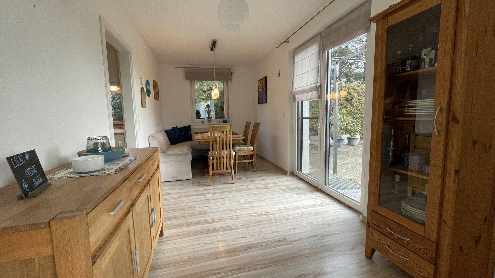 Gemütlicher Essbereich mit Holztisch und Schrank, direktem Zugang zum Außenbereich.