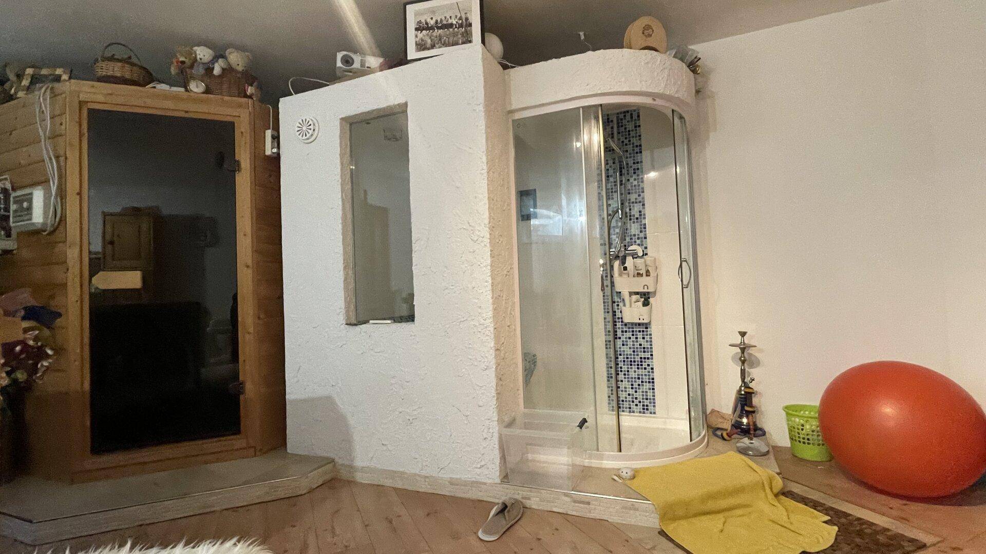 Wellnessbereich mit Sauna und Duschkabine, ideal zur Entspannung nach einem langen Tag.