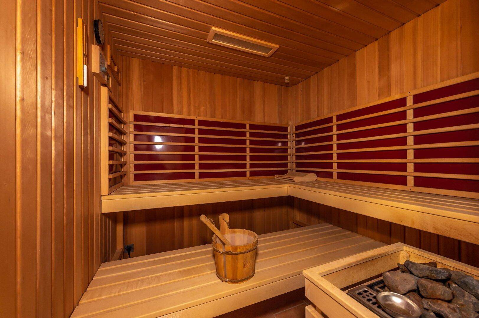 Gemütliche Sauna mit Holzbänken und traditionellem Saunaofen für Entspannung.