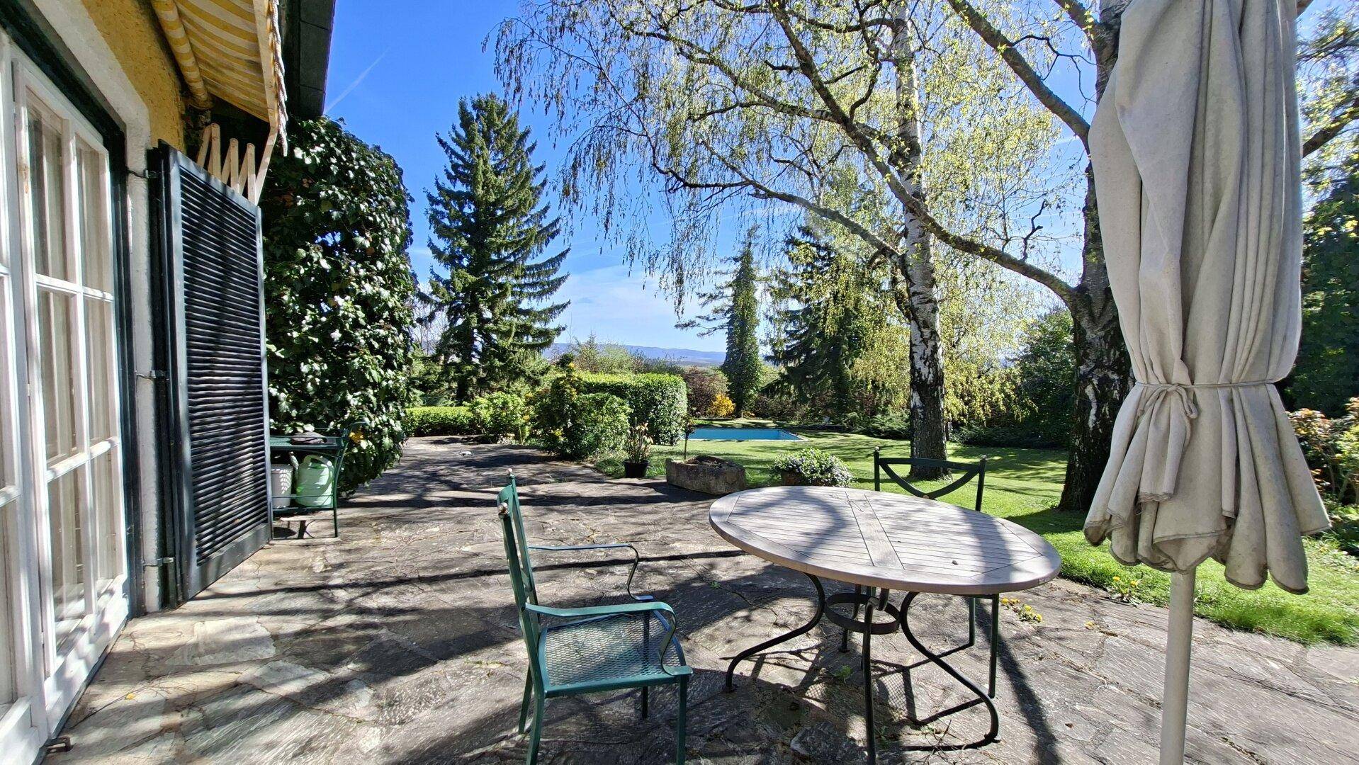 Sonnige Terrasse mit Sitzgelegenheiten und weitem Blick über den gepflegten Garten.