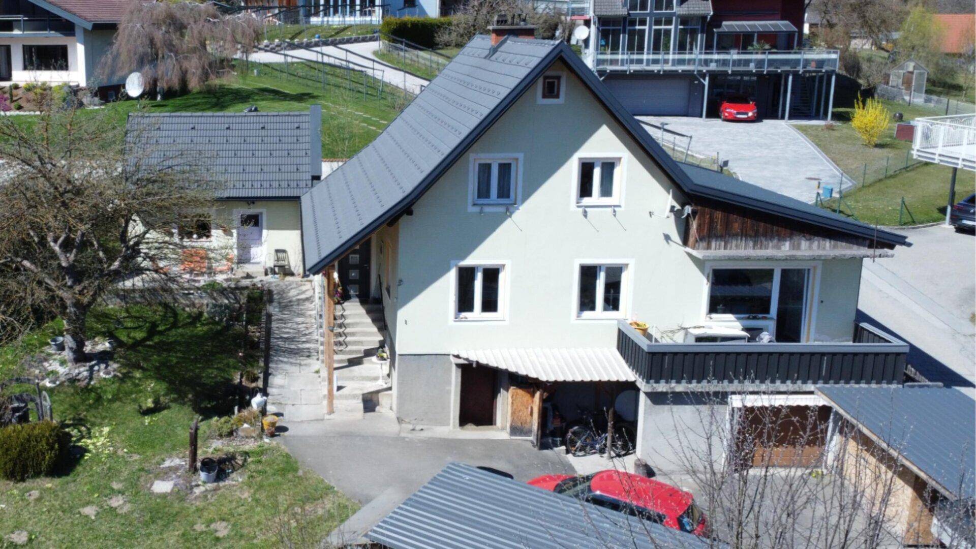 Ansicht des Hauses von oben mit Balkon, Treppe und umliegenden Gebäuden.