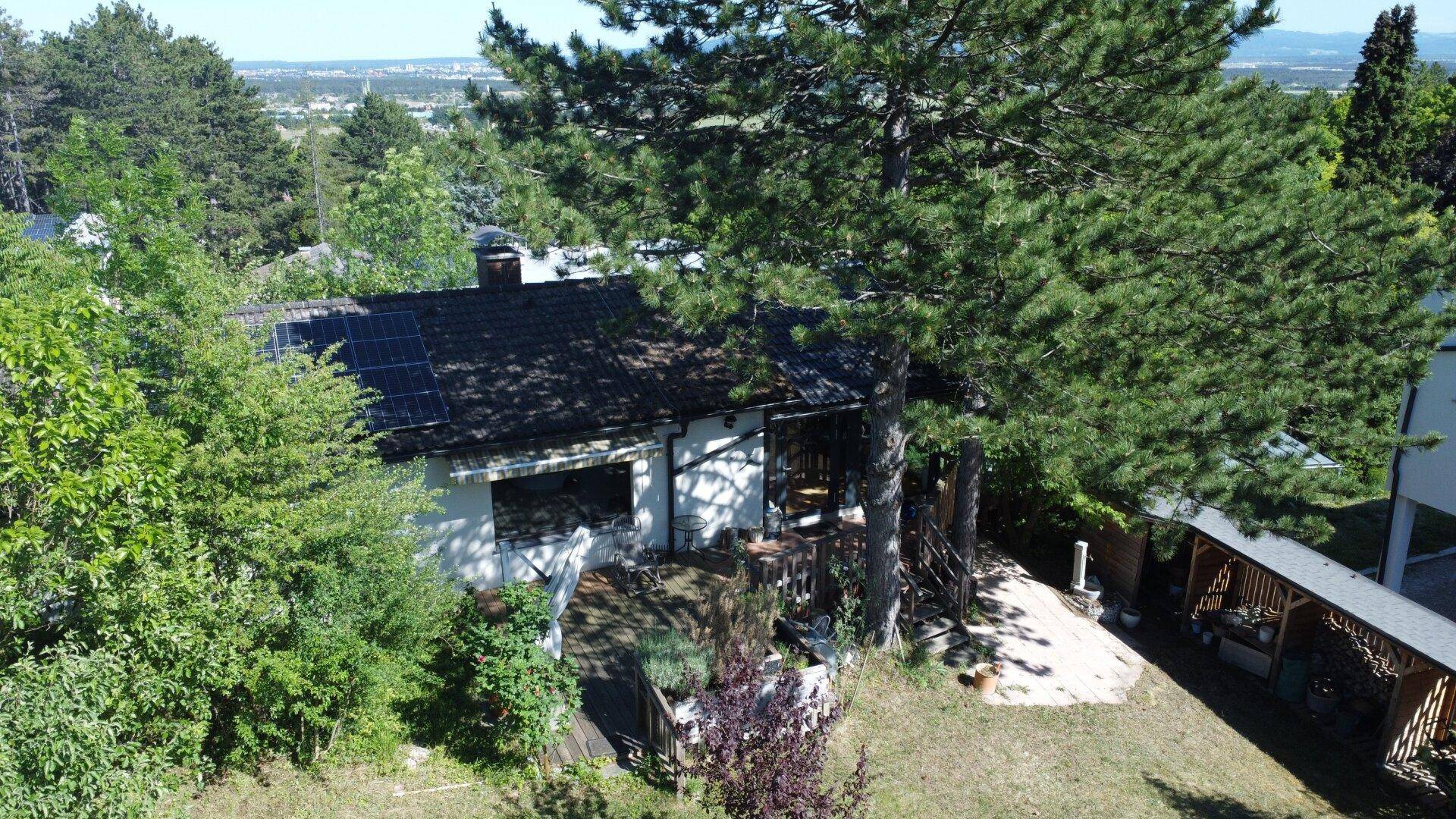 Luftaufnahme des Hauses mit Solaranlage auf dem Dach und umgebender Natur.