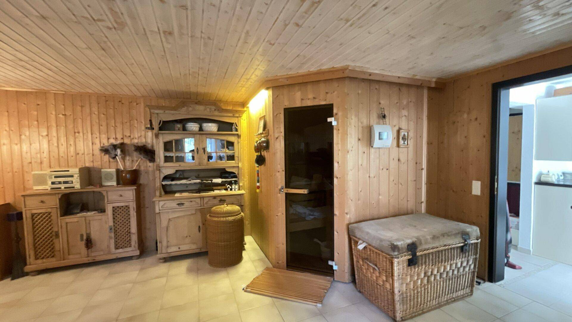Gemütlicher Wellnessbereich mit Sauna und holzvertäfelten Wänden und Decke.