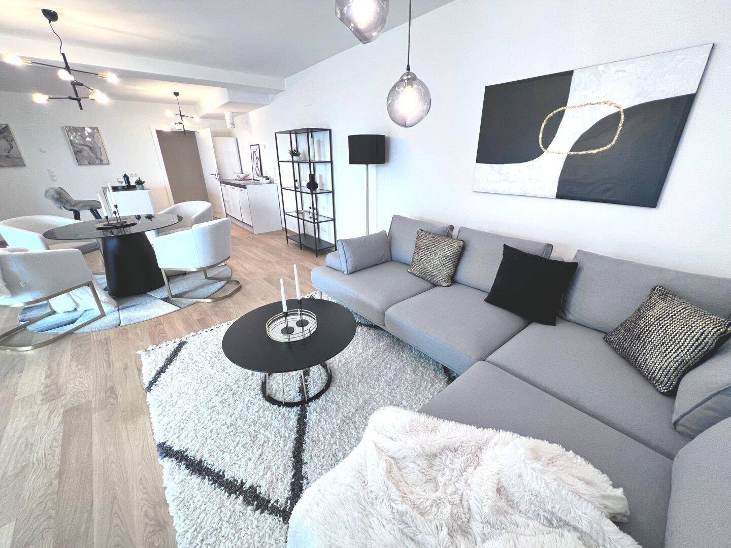 Gemütlicher Wohnbereich mit großem Ecksofa, modernem Teppich und stilvoller Dekoration.