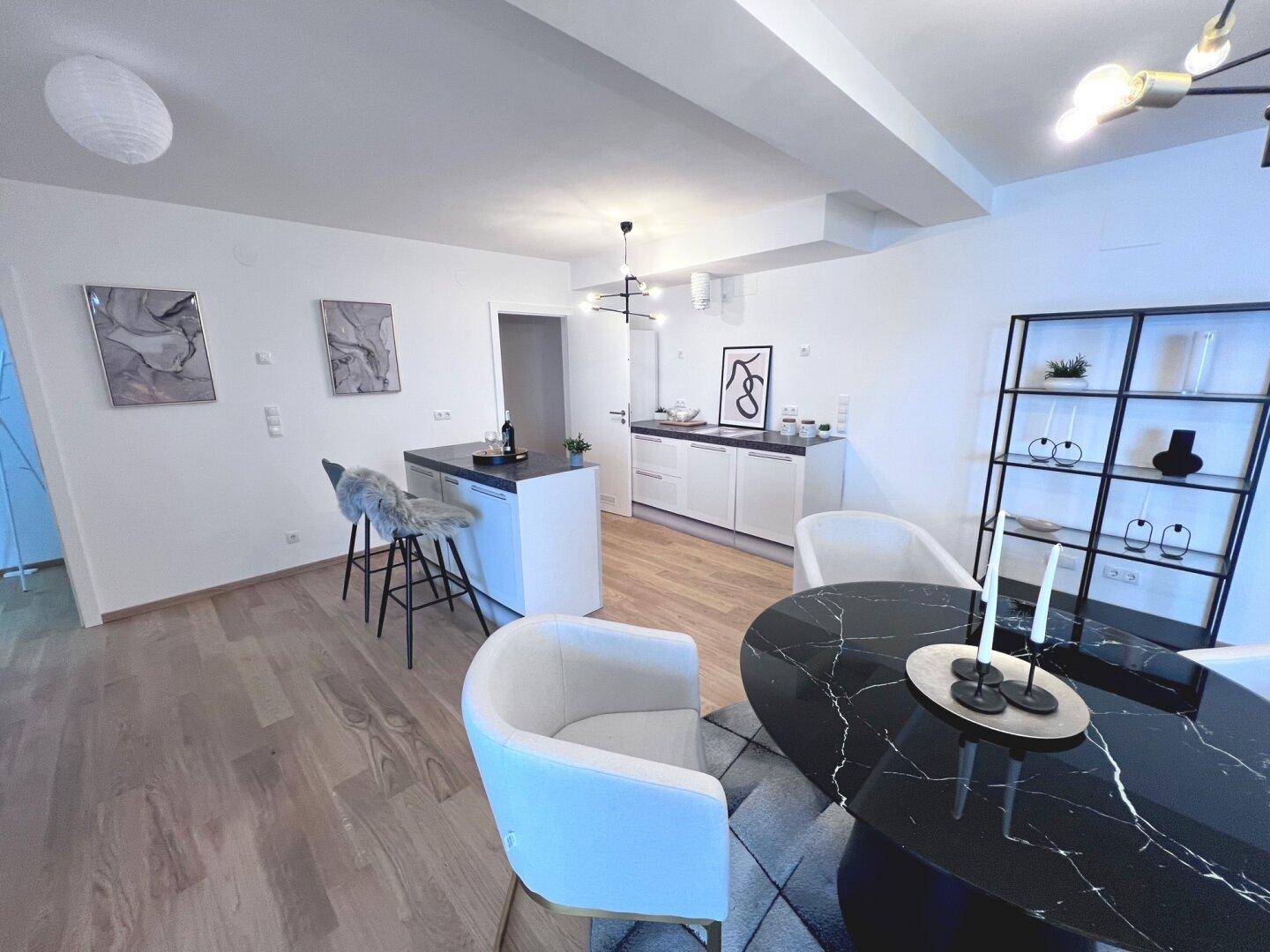 Moderne Küche mit Kochinsel und Essbereich, integriert in den offenen Wohnraum.