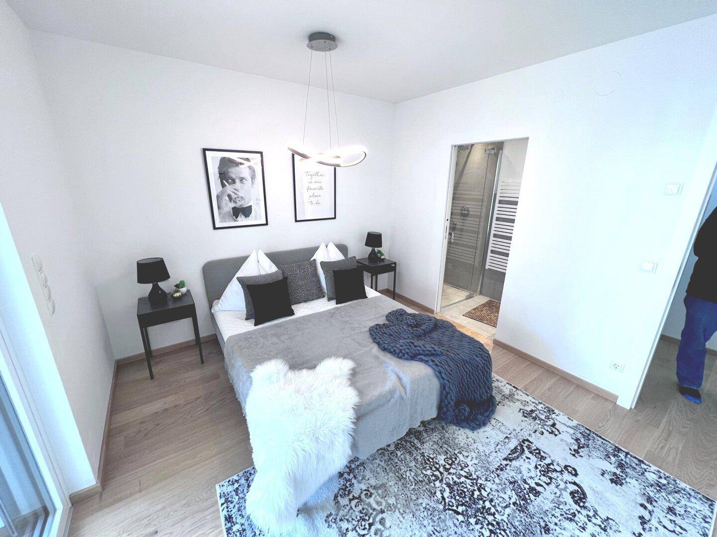 Schlafzimmer mit modernem Bett und direktem Zugang zu einem angrenzenden Badezimmer.