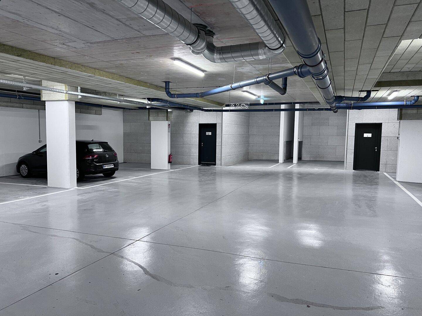 Geräumige Tiefgarage mit Betonboden und ausreichend Stellplätzen für Fahrzeuge.
