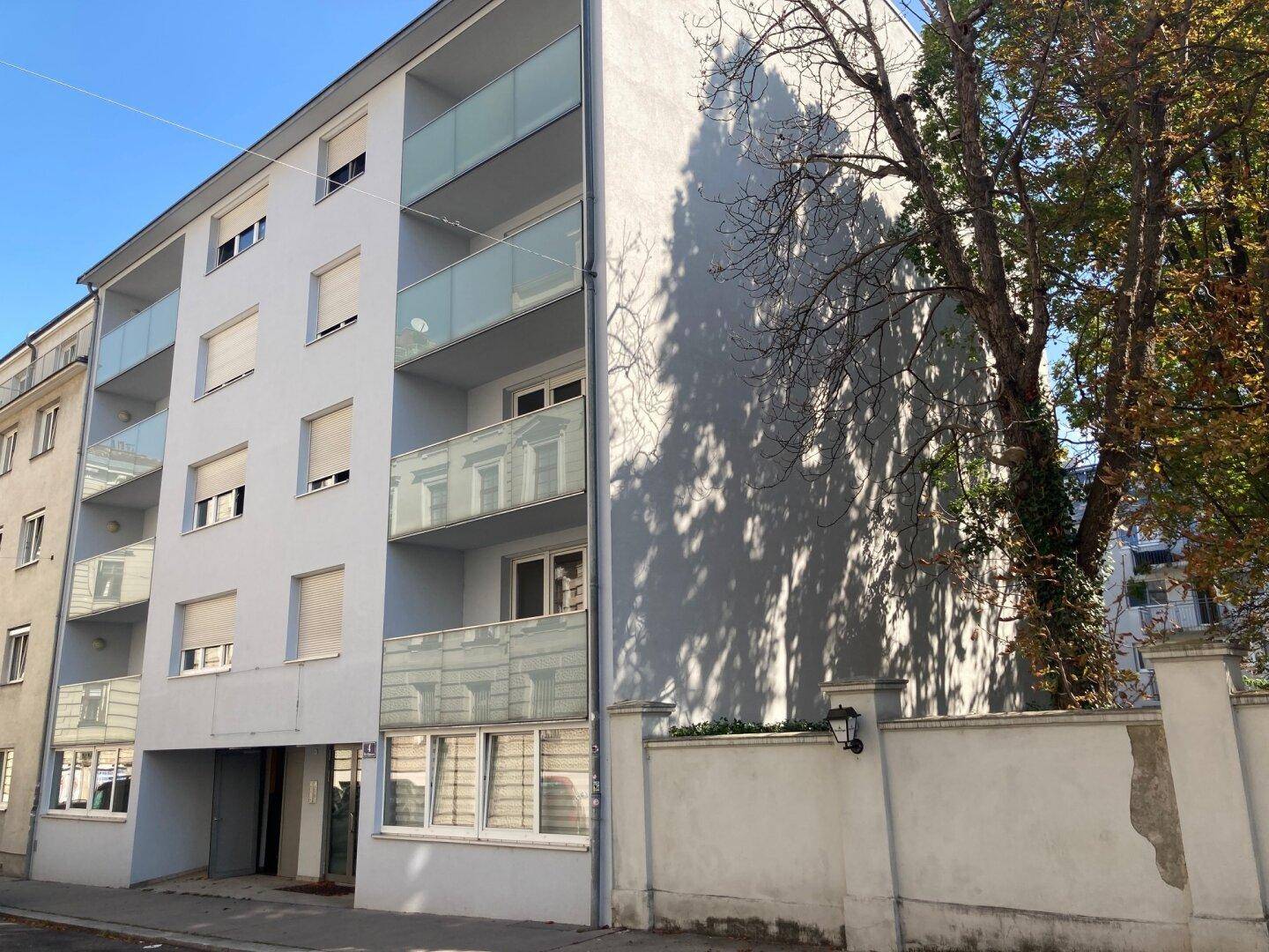 Mehrfamilienhaus mit moderner Fassade und Balkonen.