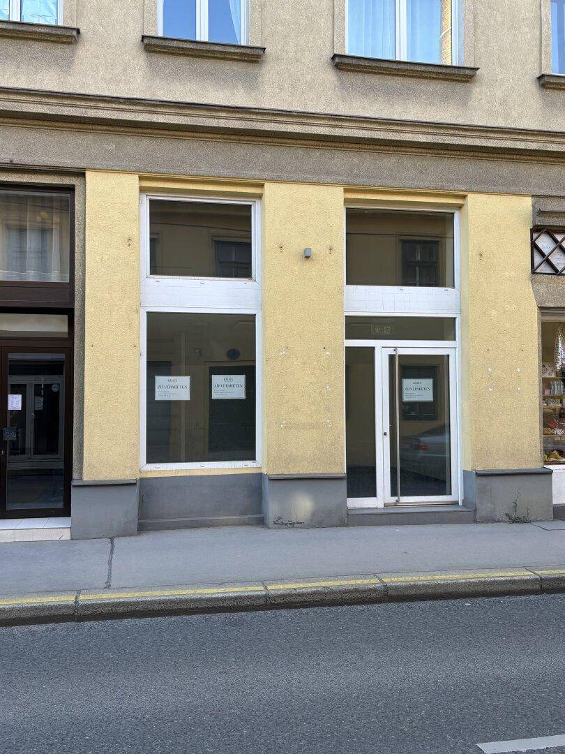 Erdgeschossfassade mit großen Schaufenstern und Eingangstür, ideal für ein Geschäft oder Büro.