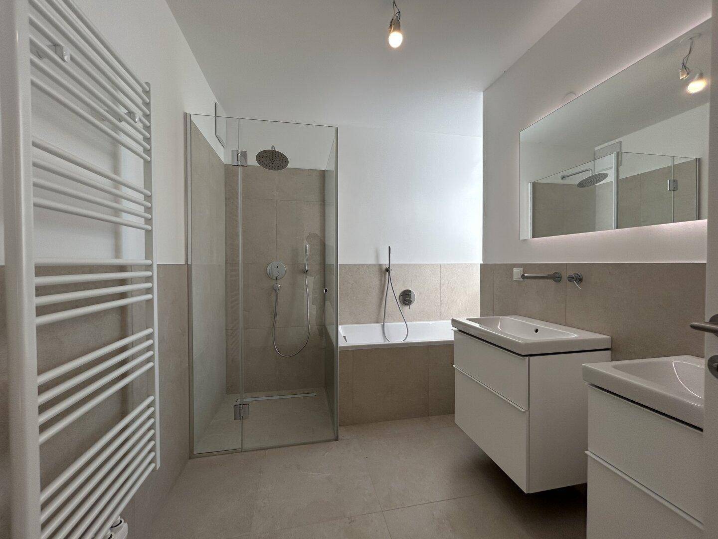 Elegantes Badezimmer mit großer Dusche, Badewanne und beheiztem Handtuchhalter für Komfort.