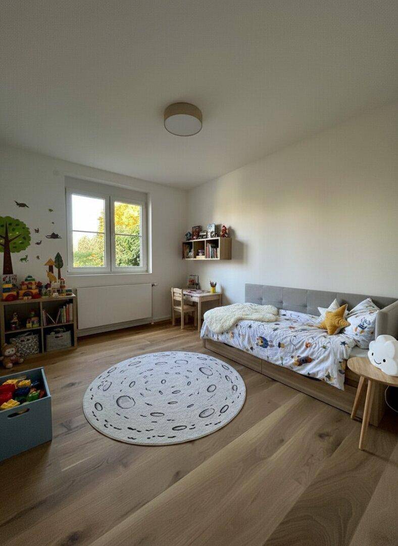 Kinderzimmer mit Holzboden, Fenster und spielerischer Dekoration.